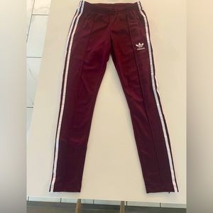 Adidas sports pants with adjustable zipper on bottom of pant.